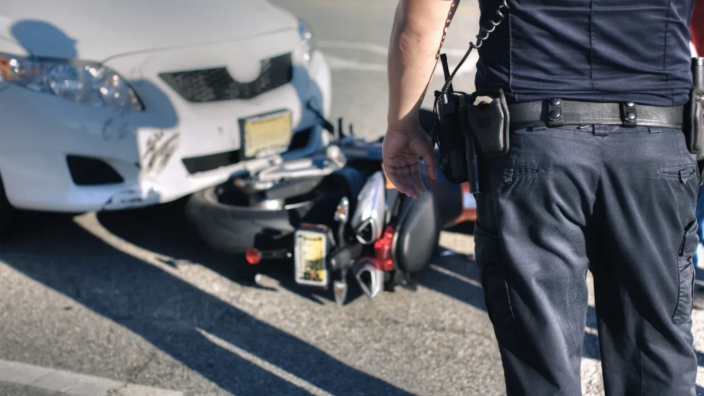 A police officer overlooking the scene of a motorcycle and car accident in Oklahoma